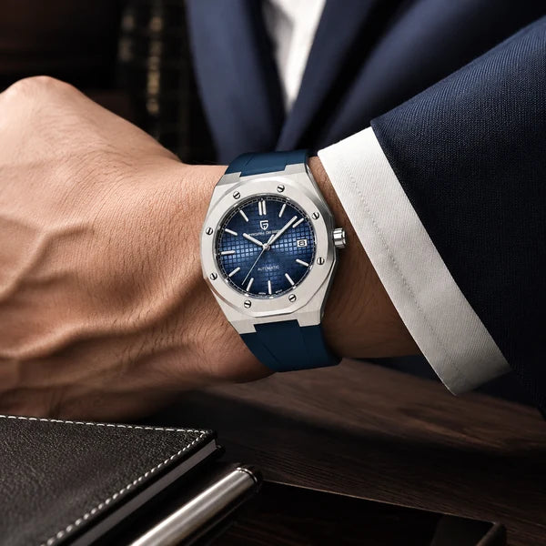 Rel?gio masculino com pulseira de borracha azul no pulso em ambiente executivo de luxo