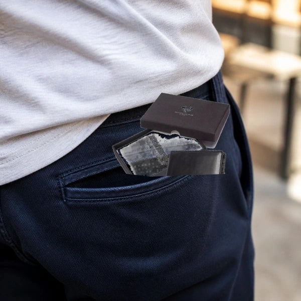 Carteira Masculina HumerPaul Maison Preta com Caixa sendo colocada no bolso em visual casual